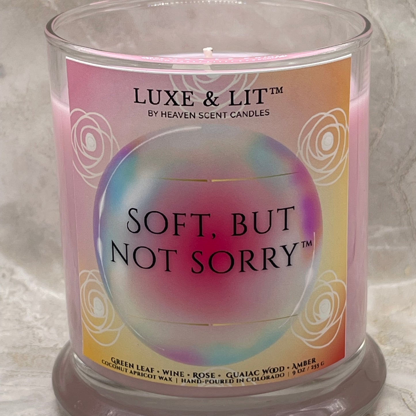 Luxe & Lit candle with 'Soft, But Not Sorry' text on a marble surface